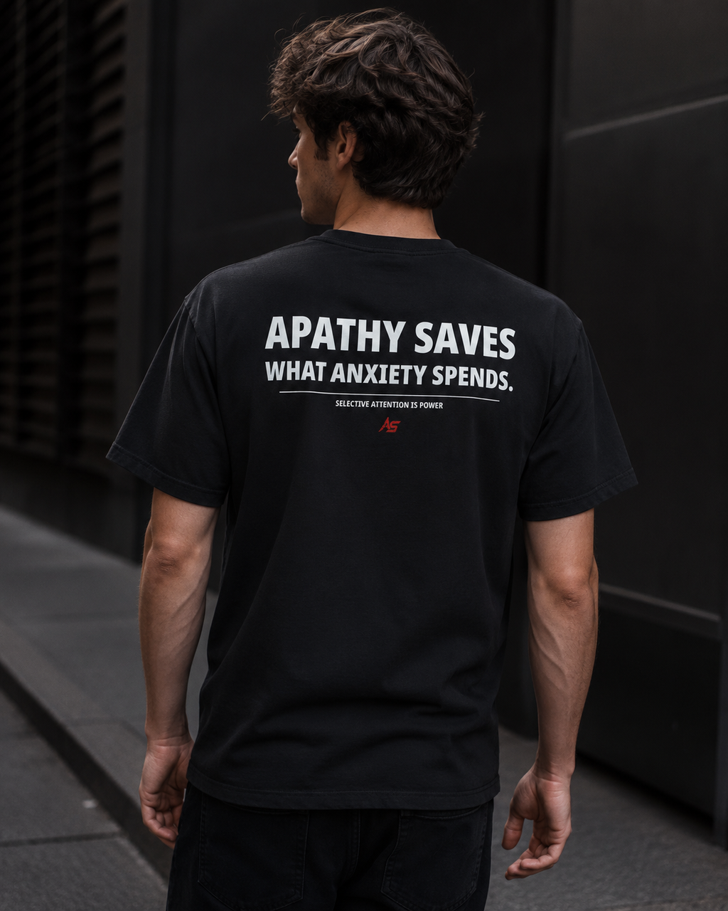 Male model wearing black ApathySaves t-shirt showing back print Apathy Saves What Anxiety Spends