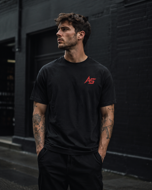 Male model wearing black ApathySaves t-shirt with small red AS logo on front chest