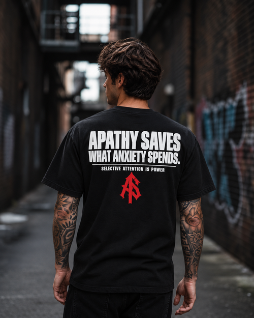 Back view of man wearing ApathySaves black T-shirt with Apathy Saves What Anxiety Spends statement and red AS logo